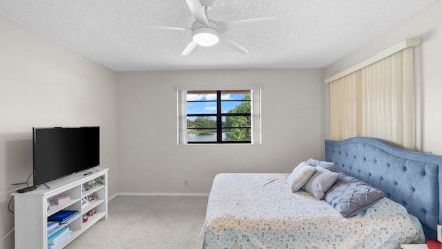 bedroom with ceiling fan, a textured ceiling, and light colored carpet