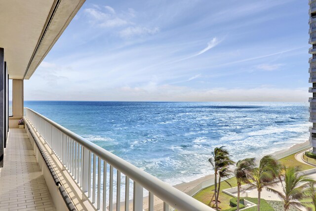 balcony with a water view and a beach view