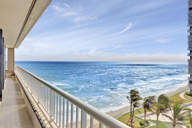 balcony with a water view and a view of the beach