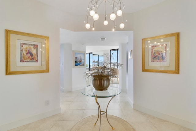 hall with a chandelier and light tile patterned flooring