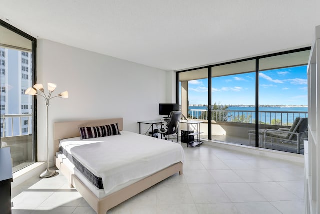 bedroom featuring floor to ceiling windows, a textured ceiling, and access to outside