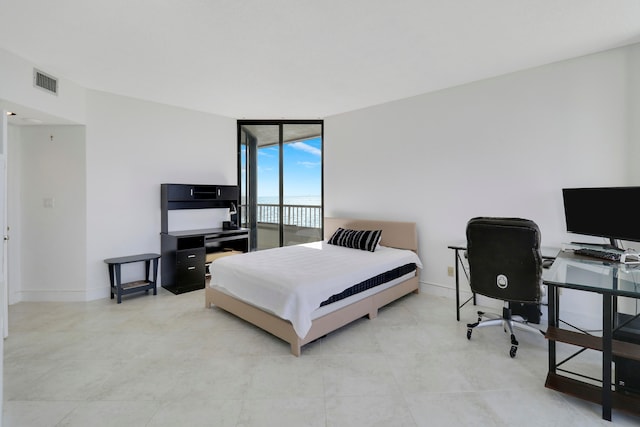 bedroom with access to outside and a wall of windows