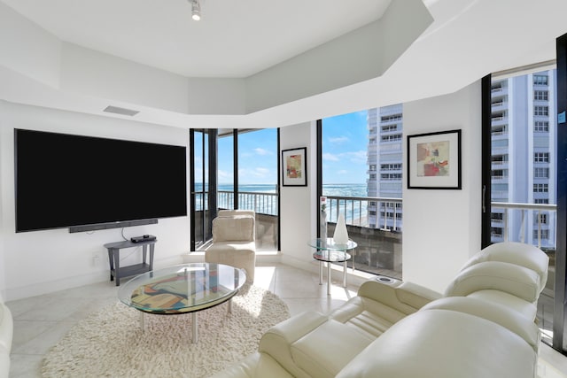 living room featuring a water view and light tile patterned floors