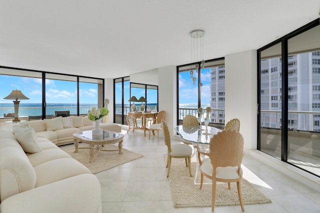 tiled living room featuring a water view, a wall of windows, and a healthy amount of sunlight