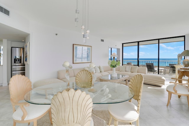 dining space with a water view and a wall of windows