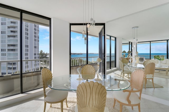 dining area with expansive windows, a water view, and light tile patterned floors