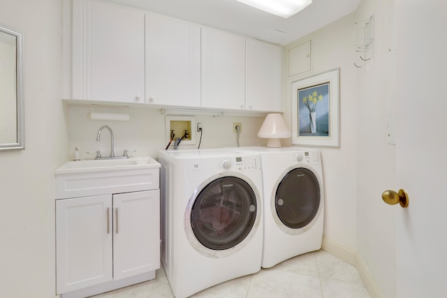 clothes washing area featuring washer and dryer, light tile patterned flooring, cabinets, and sink