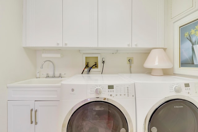 washroom featuring washer and dryer, cabinets, and sink