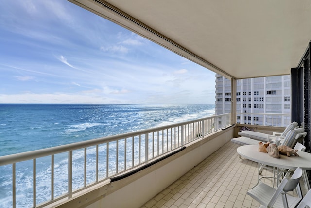 balcony featuring a water view and a view of the beach