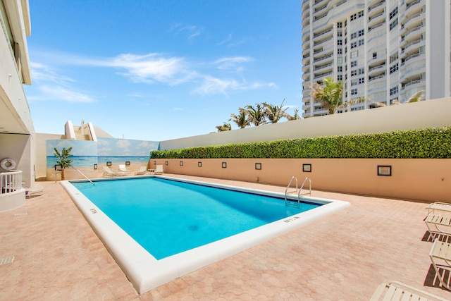 view of swimming pool featuring a patio area and a water view