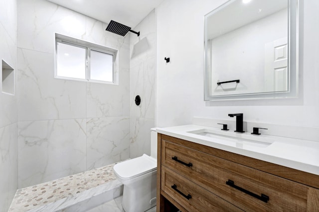 bathroom featuring tiled shower, vanity, and toilet