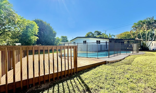 view of swimming pool featuring a yard and a wooden deck