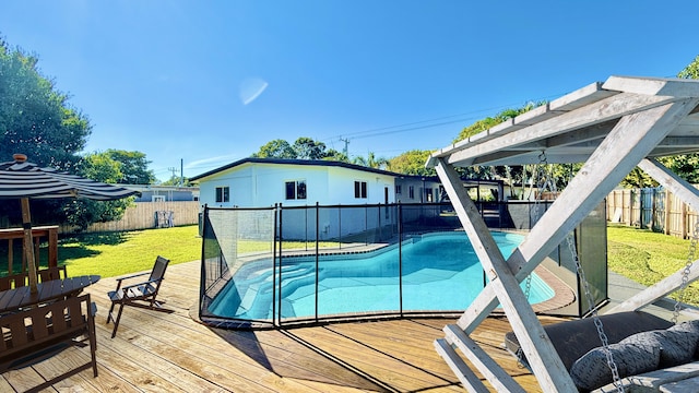 view of pool with a deck and a lawn