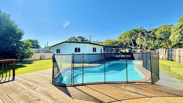 view of swimming pool with a yard and a wooden deck