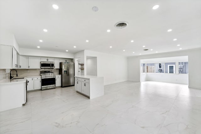 kitchen with tasteful backsplash, white cabinetry, sink, and stainless steel appliances