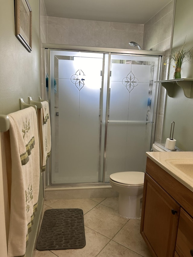 bathroom with tile patterned flooring, toilet, a shower stall, and vanity