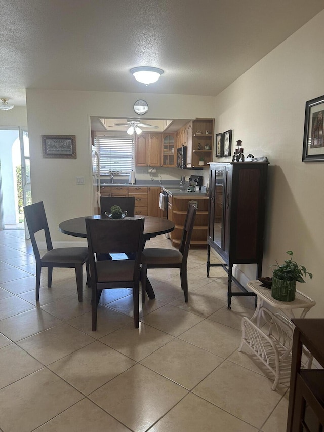 dining area featuring light tile patterned floors, a textured ceiling, and a healthy amount of sunlight