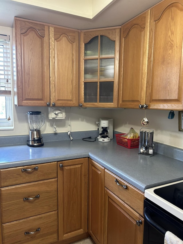 kitchen with brown cabinetry and glass insert cabinets