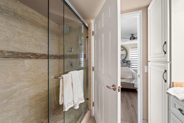 bathroom featuring hardwood / wood-style floors, vanity, a textured ceiling, and an enclosed shower