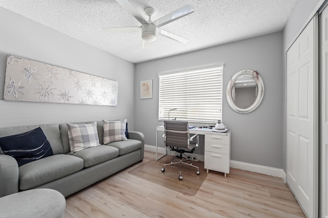 office area featuring ceiling fan, light hardwood / wood-style floors, and a textured ceiling