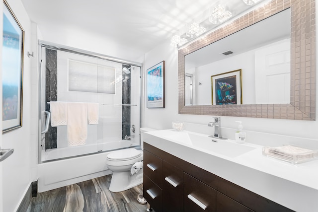 full bathroom with shower / bath combination with glass door, toilet, vanity, and hardwood / wood-style flooring