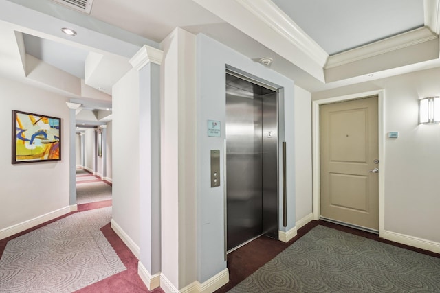 hall with elevator, crown molding, and dark colored carpet