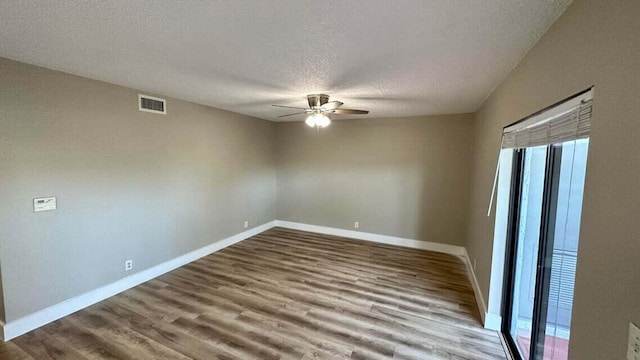 spare room featuring ceiling fan, hardwood / wood-style flooring, and a textured ceiling