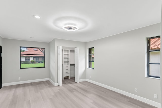 unfurnished bedroom with a closet and light hardwood / wood-style flooring