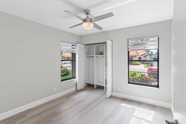 unfurnished bedroom featuring ceiling fan, light hardwood / wood-style flooring, and a closet