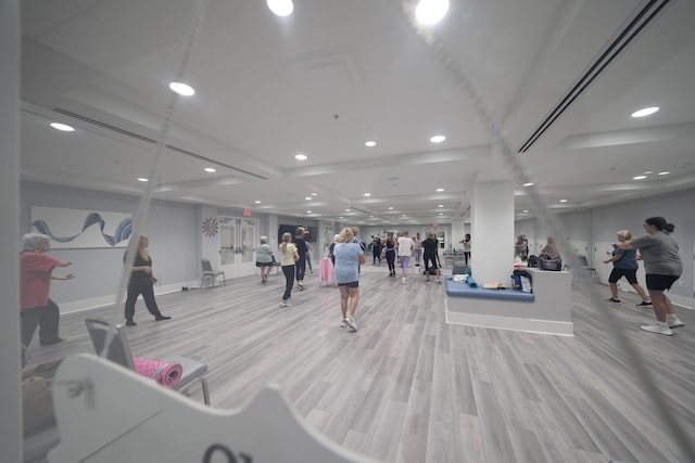 exercise room with light hardwood / wood-style floors