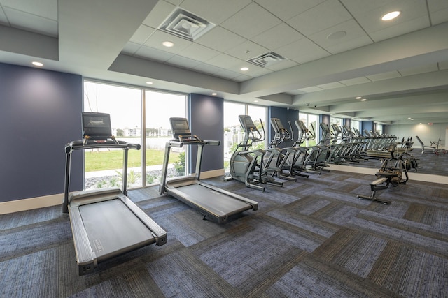 workout area featuring a wall of windows and dark carpet