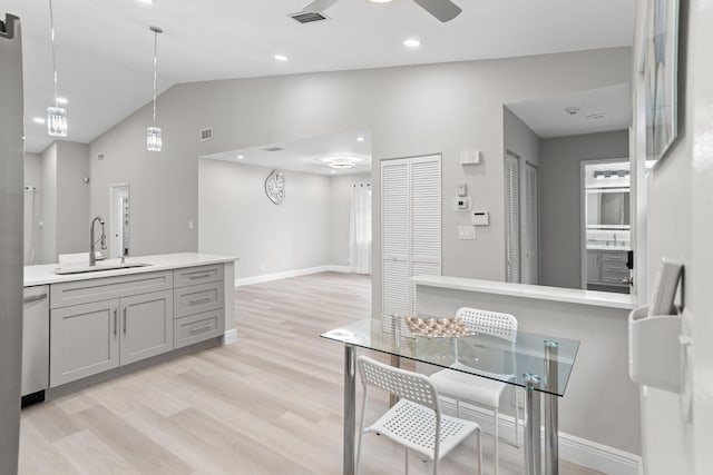 kitchen featuring dishwasher, vaulted ceiling, gray cabinets, hanging light fixtures, and sink