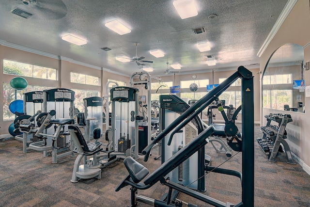 gym featuring a textured ceiling, ceiling fan, crown molding, and a wealth of natural light