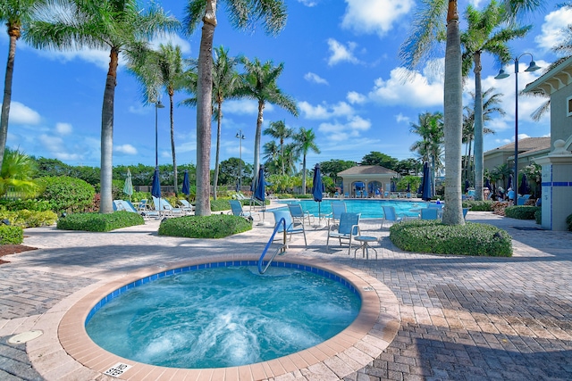 view of swimming pool featuring a community hot tub and a patio