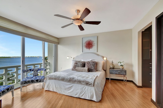 bedroom featuring ceiling fan, a water view, access to outside, and light hardwood / wood-style flooring