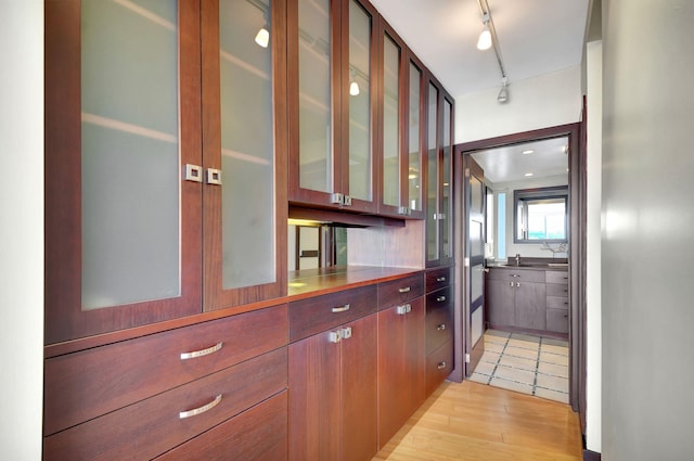 kitchen with sink, track lighting, and light wood-type flooring