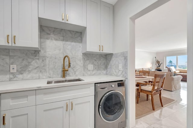 laundry room with sink, cabinets, and washer / clothes dryer