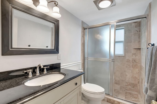 bathroom with vanity, a shower with shower door, and toilet