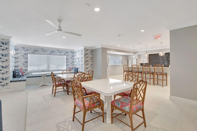 dining area featuring ceiling fan and ornamental molding