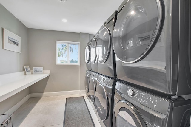 washroom with washer and clothes dryer, light tile patterned floors, and stacked washing maching and dryer