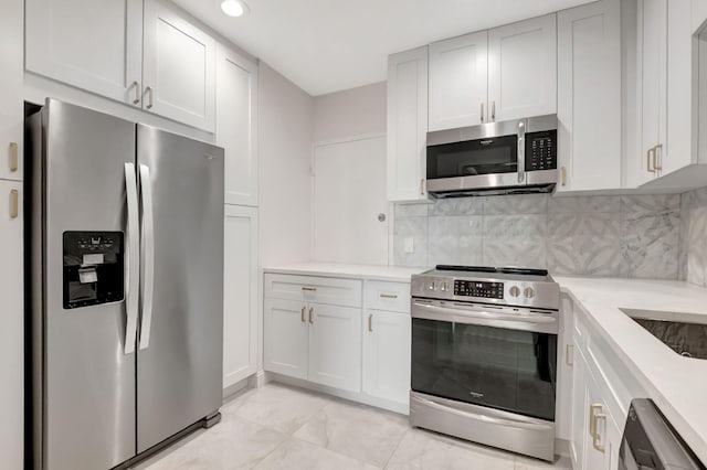 kitchen with white cabinets, stainless steel appliances, and decorative backsplash