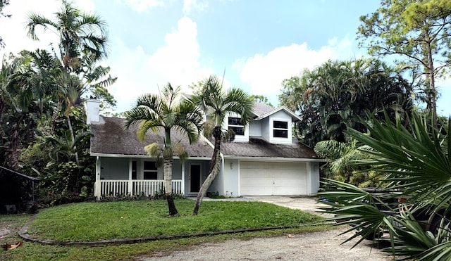 view of front of property with a front yard, a garage, and covered porch