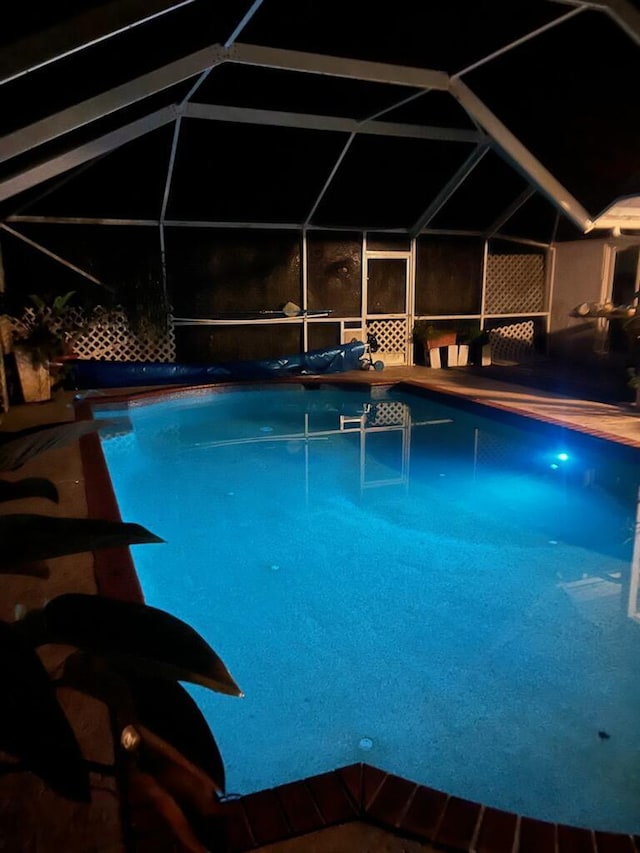 view of pool featuring glass enclosure