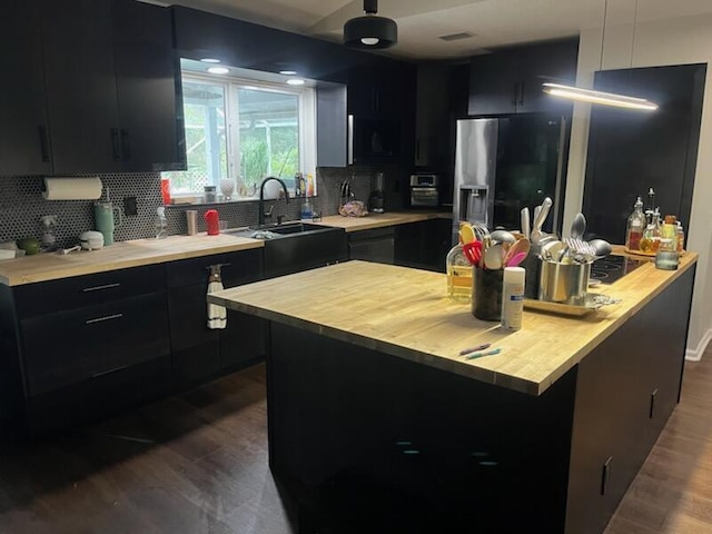 kitchen with tasteful backsplash, stainless steel fridge with ice dispenser, sink, and a kitchen island