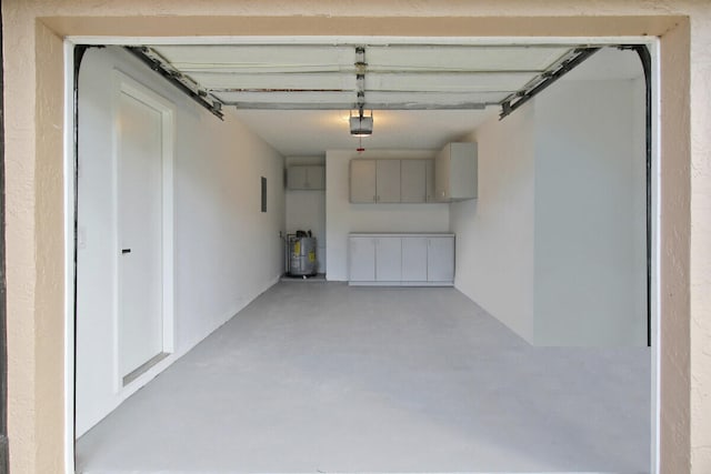 garage with secured water heater and a garage door opener