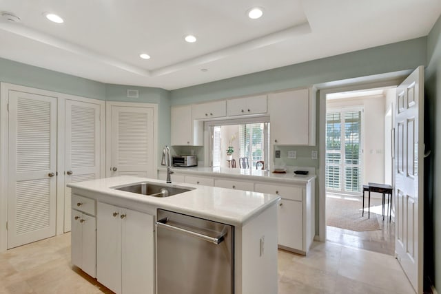 kitchen featuring white cabinetry, sink, and an island with sink