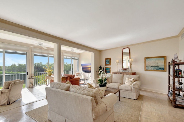 living room with light parquet flooring, ornamental molding, a healthy amount of sunlight, and ceiling fan