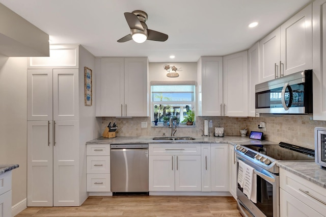 kitchen featuring white cabinetry, sink, light hardwood / wood-style floors, and stainless steel appliances