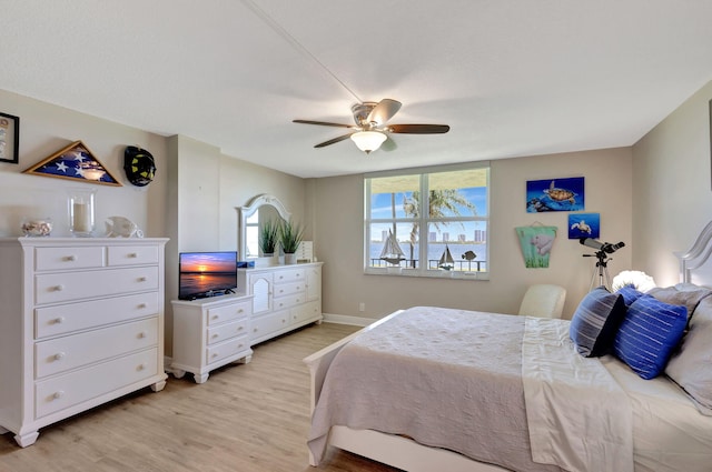 bedroom with light hardwood / wood-style floors, ceiling fan, and multiple windows