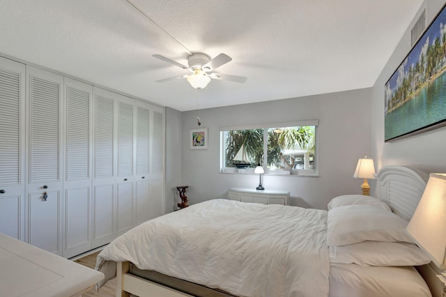 bedroom featuring light hardwood / wood-style floors, ceiling fan, a textured ceiling, and a closet